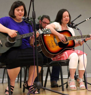 Musicians playing guitar at the Evening Entertainment event.