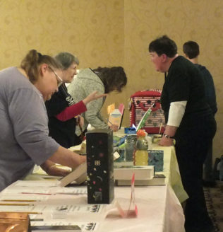 Women viewing auction table at the Evening of Entertainment event.