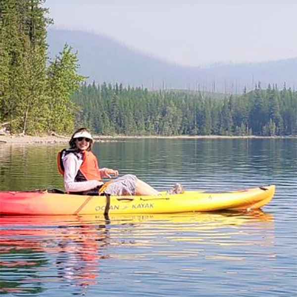 Carol kayaks on a lake.