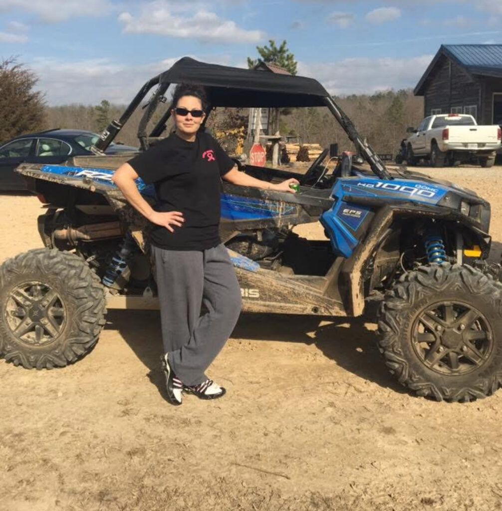 Melinda riding a side-by-side ORV